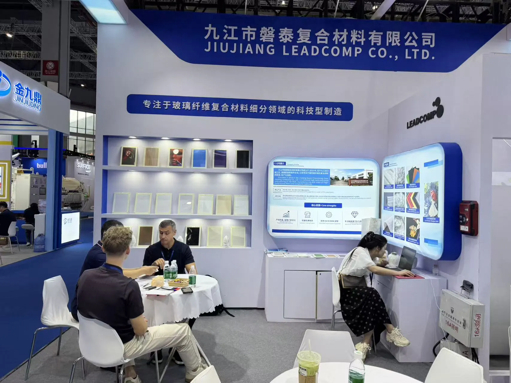 Visitors meeting with the Jiujiang Leadcomp team beside the material display